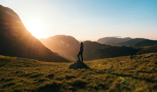 Person meditiert im Sonnenaufgang