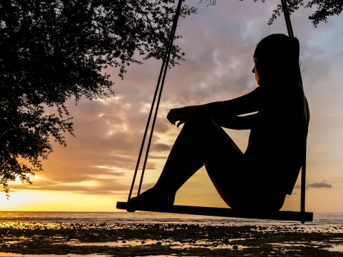 Frau genießt Sonnenaufgang am Strand