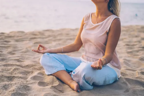 Person, die am Strand Yoga praktiziert