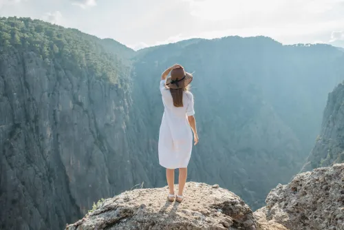 Frau steht auf Berggipfel