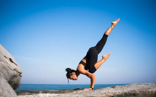 Person praktiziert Yoga am Strand