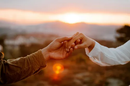 Paar geht Hand in Hand im Sonnenuntergang