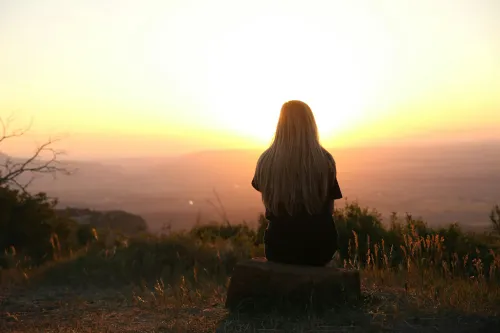 Person meditiert im Sonnenuntergang