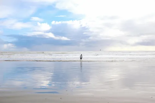 Person am Strand mit Fernglas