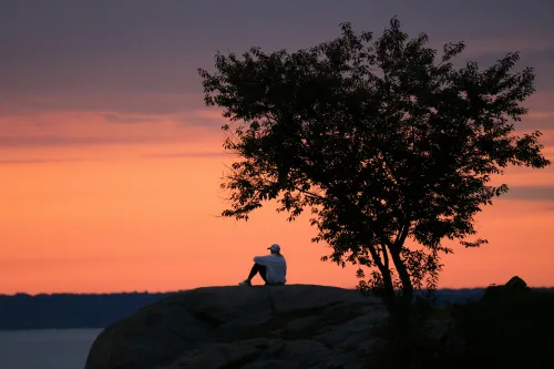 Frau meditiert zum Sonnenaufgang