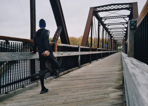 Person, die einen Fuß auf eine Brücke setzt