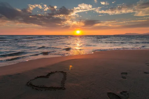 Paar, das den Sonnenuntergang am Strand genießt