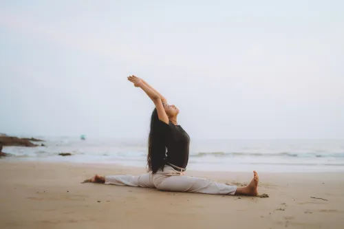 Frau macht Yoga am Strand